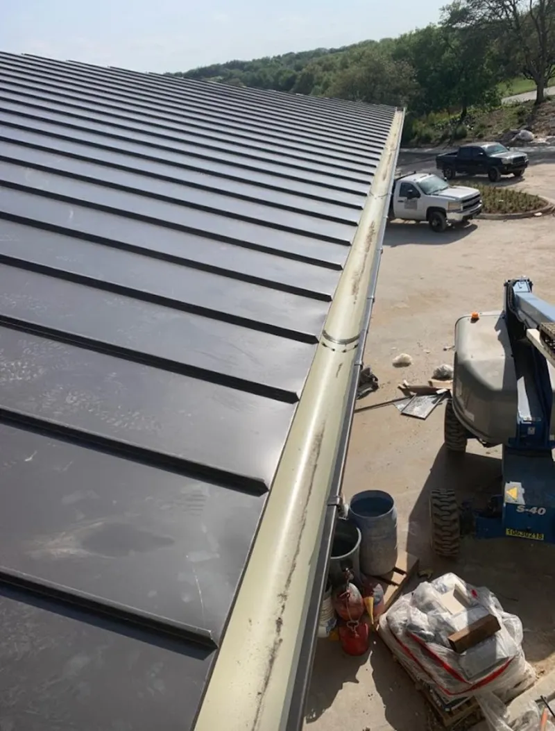 Standing seam panel and gutter detail on a metal roofing jobsite in Moberly